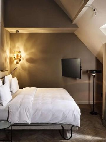 Gemütliches Schlafzimmer mit einem Doppelbett und schräger Decke