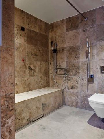 Modernes Badezimmer mit Regendusche und Steinwandverkleidung