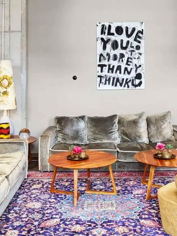 Gemütliche Lounge mit vintage Teppich und modernen Sofas, Kunstwerk an der Wand