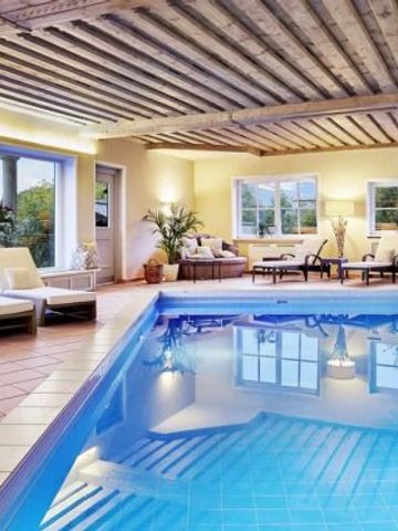 Innenpool mit gemütlichen Sitzgelegenheiten und Holzbalkendecke