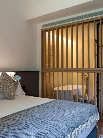 Schlafzimmer mit Holzgitterelementen und sanfter Beleuchtung.