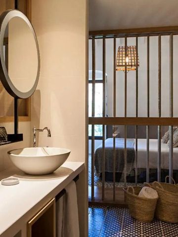 Modernes Badezimmer mit Waschbecken und Blick ins Schlafzimmer