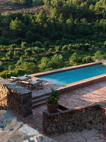 Landschaft mit Pool und Aussicht auf grüne Hügel und Wälder