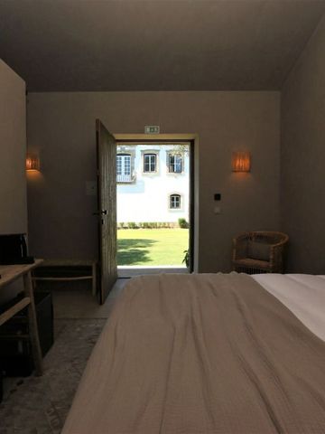 Geräumiges Hotelzimmer mit großem Bett und offener Tür zum Garten