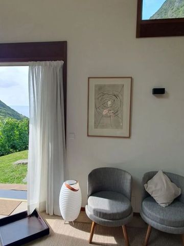 Helles Zimmer mit stilvollen Sesseln und Aussicht auf die Natur.