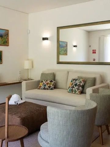 Gemütliche Lounge mit Sofa, Spiegel und stilvollen Kunstwerken.