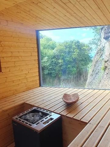 Sauna mit großem Fenster und Blick auf Felsen und Wald