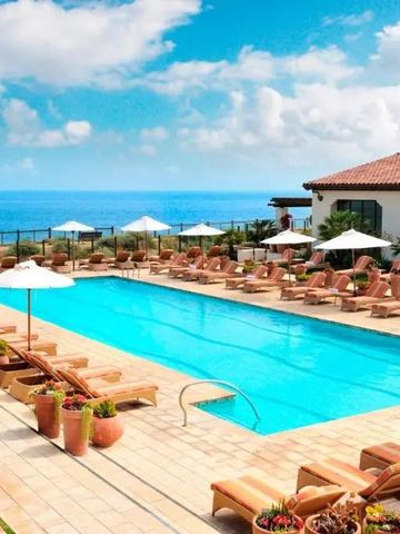 Großer Poolbereich mit Liegen und Ausblick auf den Ozean