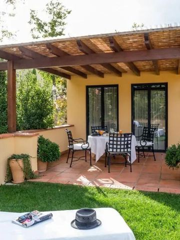 Sonnige Terrasse mit bequemer Liege und Sitzgarnitur im grünen Garten.