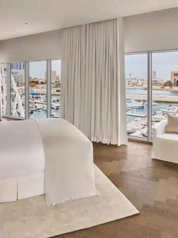 Luxuriöses Schlafzimmer mit Blick auf den Hafen. Großes Bett mit heller Bettwäsche.