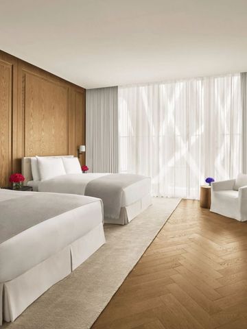 Geräumiges Zimmer mit zwei Betten. Holzboden und lichtdurchflutete Fenster.