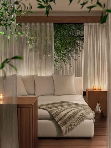 Gemütliche Lounge mit Sitzgelegenheit. Dekoriert mit Pflanzen und Kerzen.