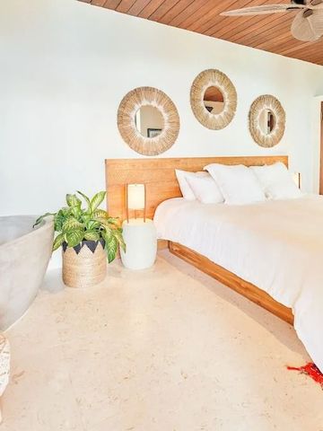 Modernes Schlafzimmer mit Deko-Elementen und freistehender Badewanne im Hintergrund