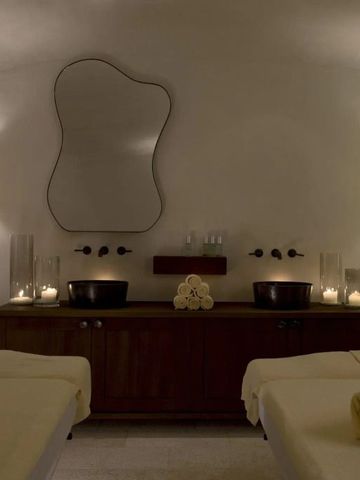 Luxuriöser Spa-Behandlungsraum mit gedämpfter Beleuchtung und zwei Massageliegen