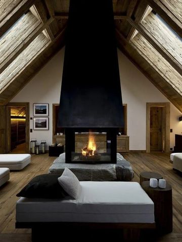 Großzügiger Raum mit offenem Kamin und Holzbalkendecke