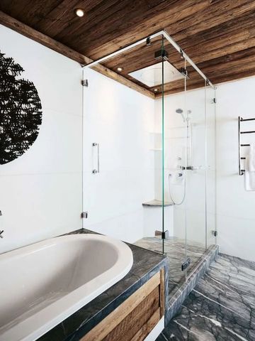 Modernes Badezimmer mit Glasdusche und Holzdecke