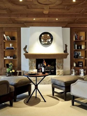 Gemütliches Kaminzimmer mit Sesseln und Bücherregalen