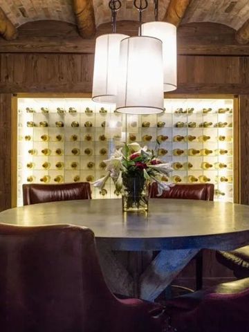 Gemütlicher Weinkeller mit rundem Tisch und warmem Licht