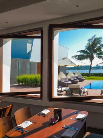 Eleganter Poolbereich mit Liegen und Palmenblick durch große Fenster.