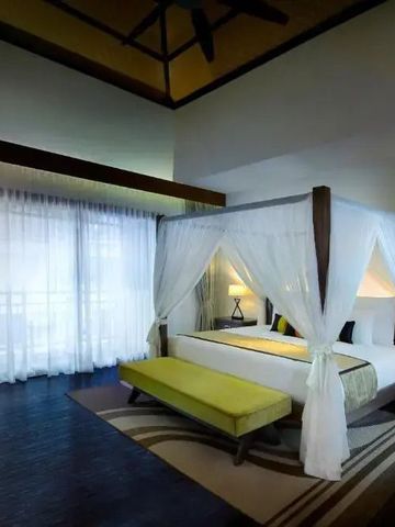 Helles Schlafzimmer mit Himmelbett und großen Fenstern