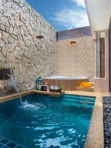 Privater Poolbereich mit Natursteinmauern und blauer Kachelung