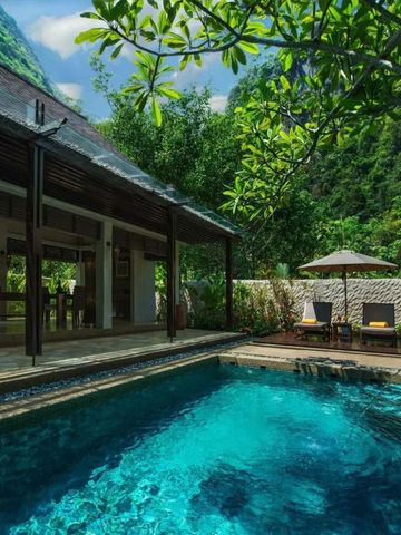 Tropischer Villenpool umgeben von üppigem Grün und Liegeflächen