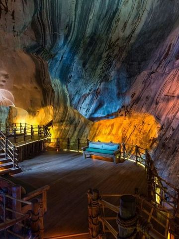 Spektakuläre Höhlenlandschaft mit beleuchtetem Pfad und Sitzbereich