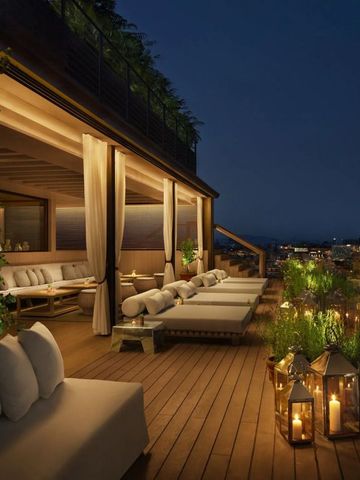 Rooftop-Terrasse bei Nacht mit gemütlichen Sitzgelegenheiten und romantischer Beleuchtung