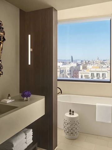 Luxuriöses Badezimmer mit freistehender Badewanne und großem Fenster mit Stadtblick