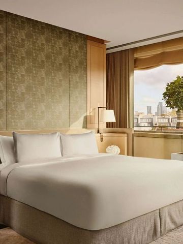 Geräumiges Schlafzimmer mit Kingsize-Bett und weitem Stadtblick aus dem Fenster.