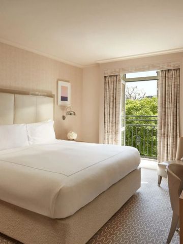 Helles Gästezimmer mit Balkon und Blick auf grüne Landschaft im The Berkeley.