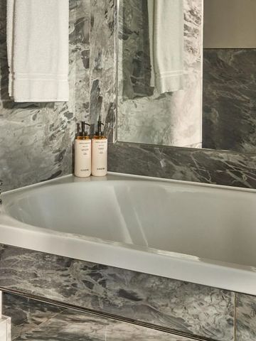 Luxuriöses Badezimmer mit Marmor und Badewanne.