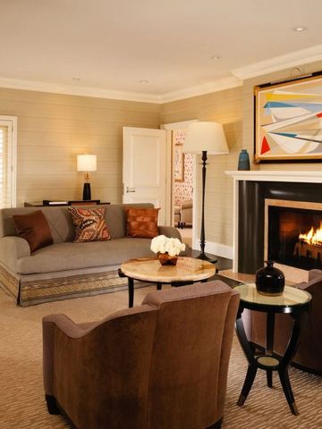 Wohnbereich mit gemütlichem Sofa und Kamin im luxuriösen Hotelzimmer