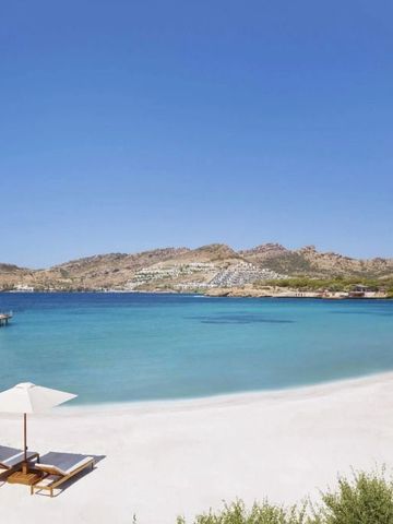 Sonniger Sandstrand mit Liegestühlen und klarem blauem Meer