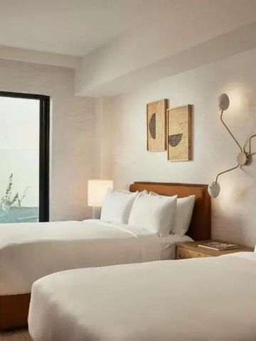 Hotelzimmer mit zwei Einzelbetten und Zugang zur privaten Terrasse.