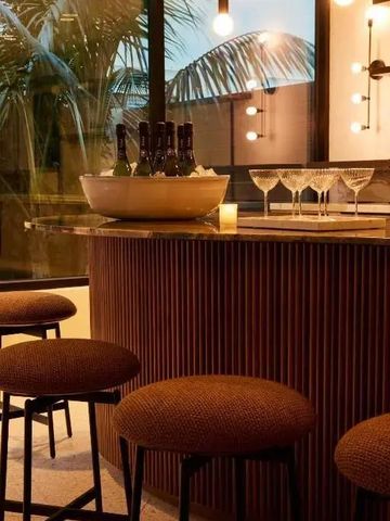 Gemütliche Bar mit Hockern und Champagnerflaschen im Hotel
