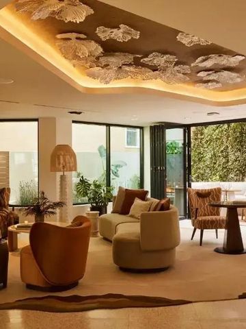 Lounge mit stilvollen Sofas und kunstvoller Decke im Hotel