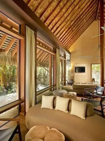 Luxuriöses Wohnzimmer in einer Villa mit hohen Holzdecken und großen Fenstern