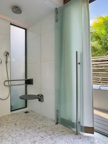 Elegantes Badezimmer einer Villa mit Dusche und Ausblick auf Palmen