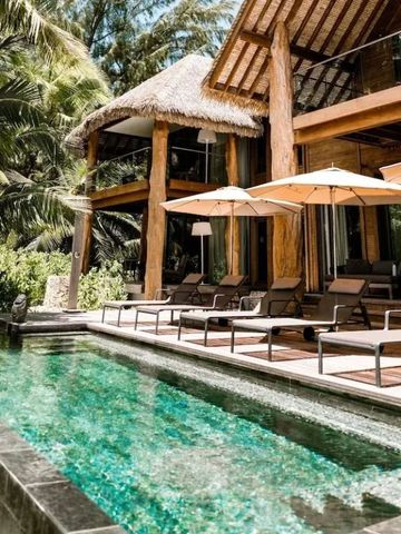 Villa mit Pool und Sonnenliegen unter Palmen