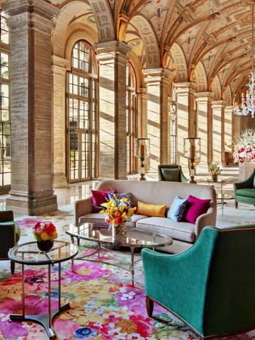 Elegante Hotel-Lobby mit hohen Decken und üppigen Blumenarrangements.