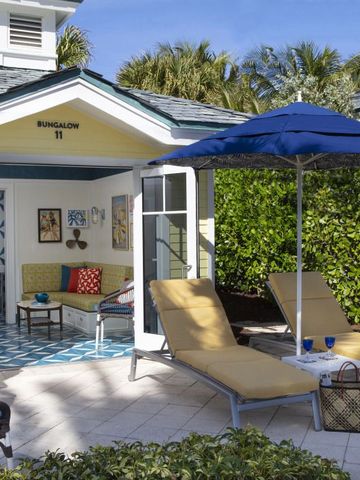 Lichtdurchfluteter Bungalow mit privater Terrasse und Liegestühlen.