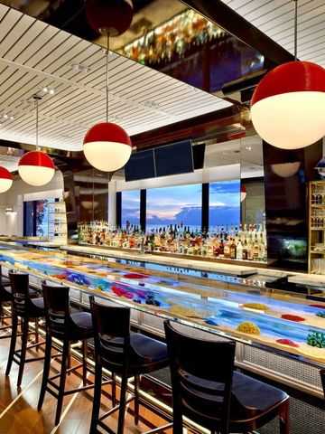 Elegante Hotelbar mit stilvollen Hängelampen und einer gut bestückten Theke.