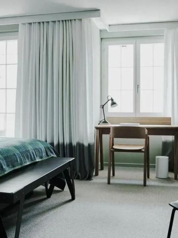 Helles Zimmer mit Schreibtisch und großem Fenster im The Cambrian Adelboden