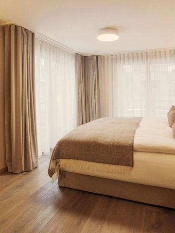 Modernes Hotelzimmer mit großem Bett und warmen Holztönen