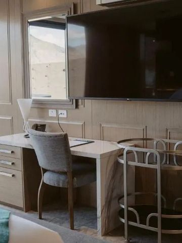 Helles Hotelzimmer mit Schreibtisch und großem Fernseher