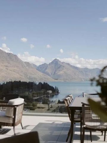 Blick von der Terrasse auf den See und die Berge mit Sitzgelegenheiten.