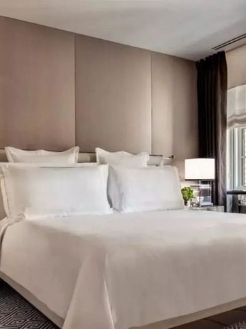 Geräumiges Hotelzimmer mit großem Bett und natürlichen Materialien. Licht durch Fenster