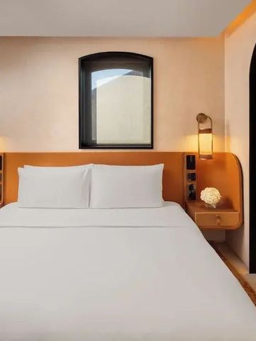 Modernes Hotelzimmer mit elegantem Doppelbett und goldenen Lampen