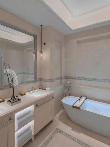 Modernes Badezimmer mit freistehender Badewanne und großen Spiegeln